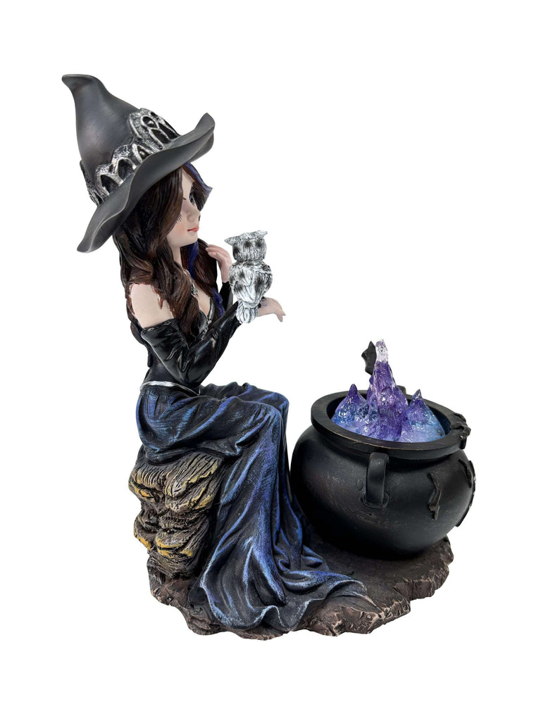 Statue of a witch with a cauldron and crystals on a white background