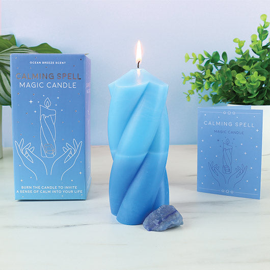 Blue twisted candle with packaging labeled 'Calming Spell' on a light background