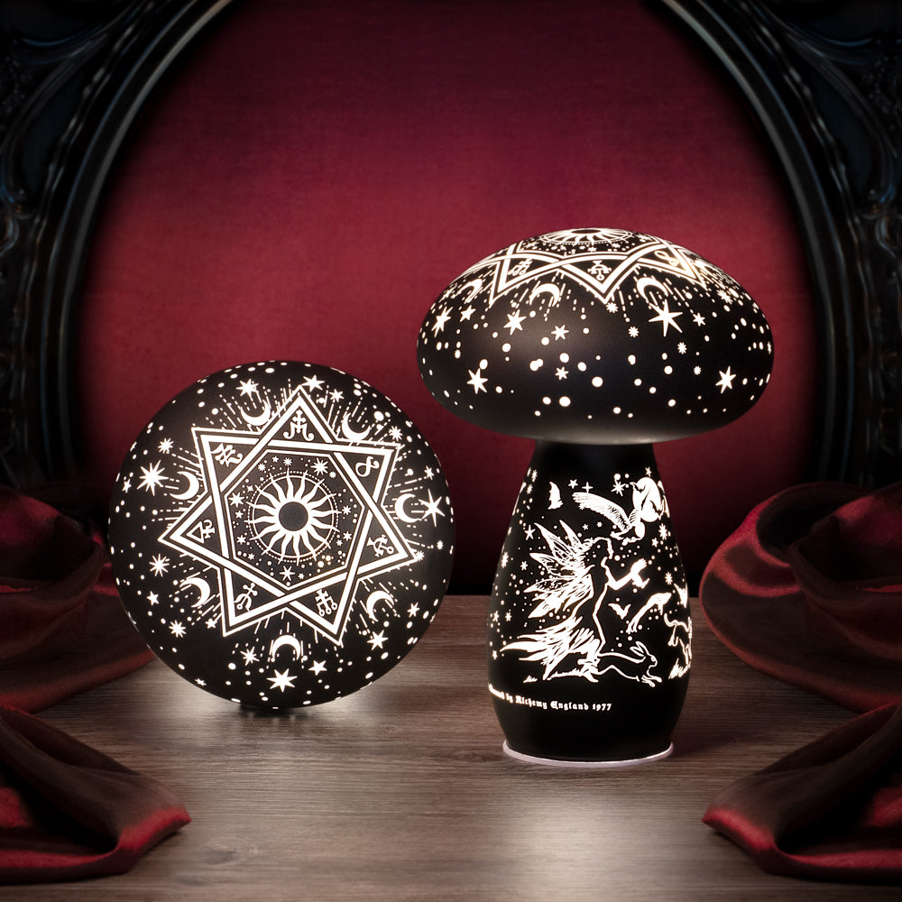 Decorative black and white mushroom-shaped lamp with star and geometric patterns on a dark background.