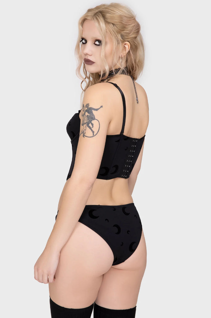 Woman wearing a black lingerie set with a white background