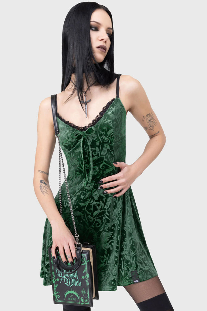 Woman wearing a green lace dress with a white background