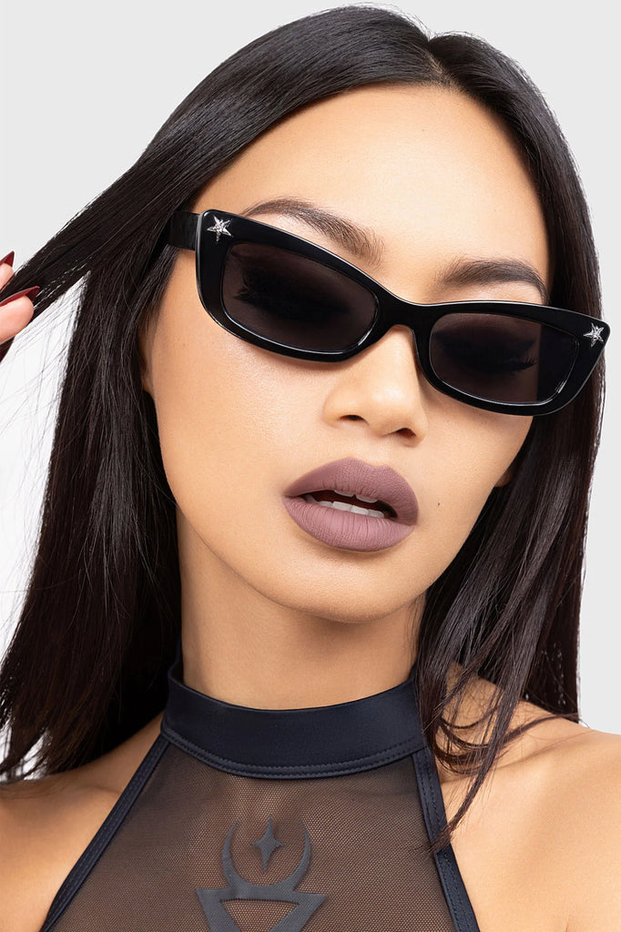 Woman wearing black sunglasses with a neutral background