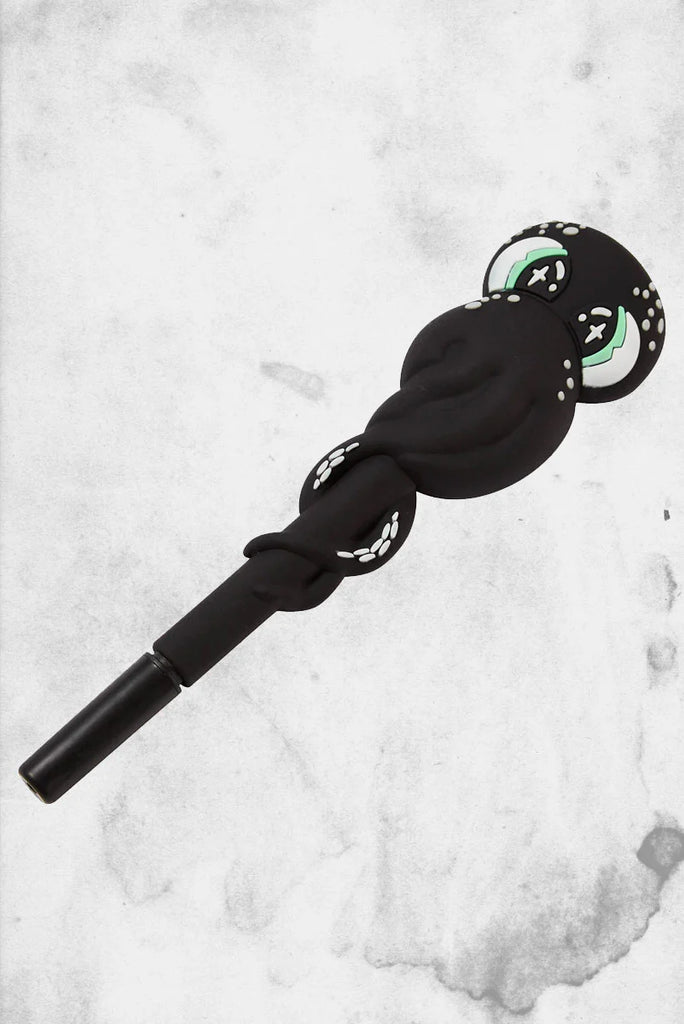 Black hair tie with green accents on a white marble background