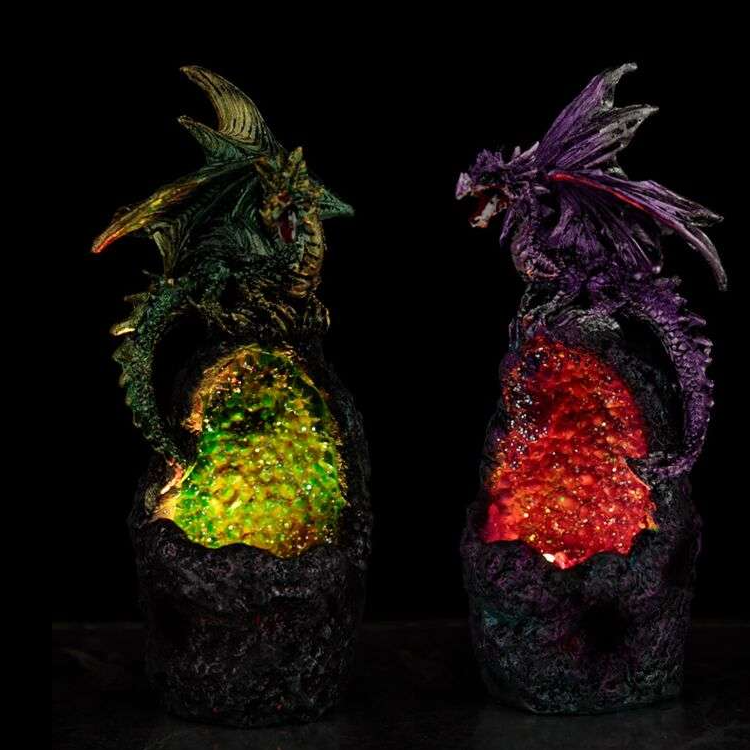 Two dragon-shaped lamps with colorful glowing cores on a black background