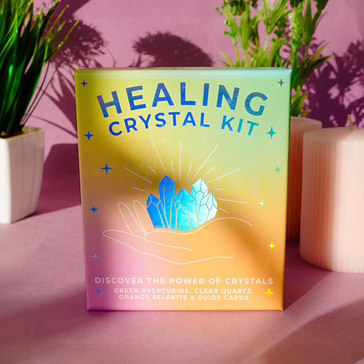 Healing crystal kit packaging with crystals and text on a pink background