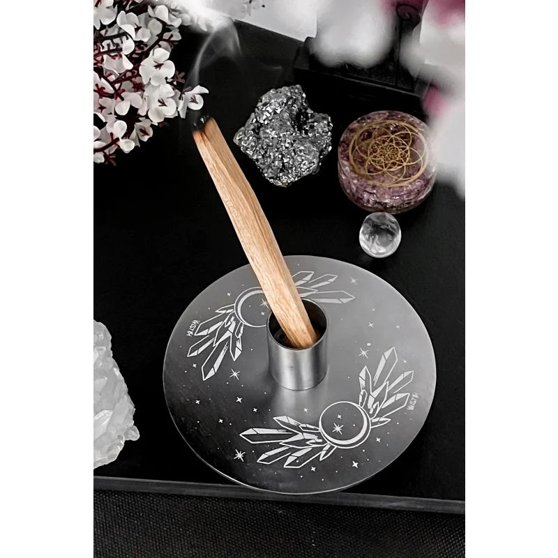 Incense holder with wooden stick on a black surface with decorative items