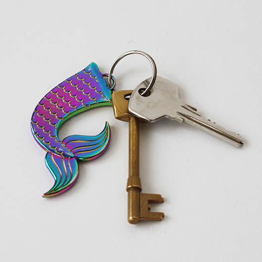 Keychain with mermaid tail design and two keys on a white background