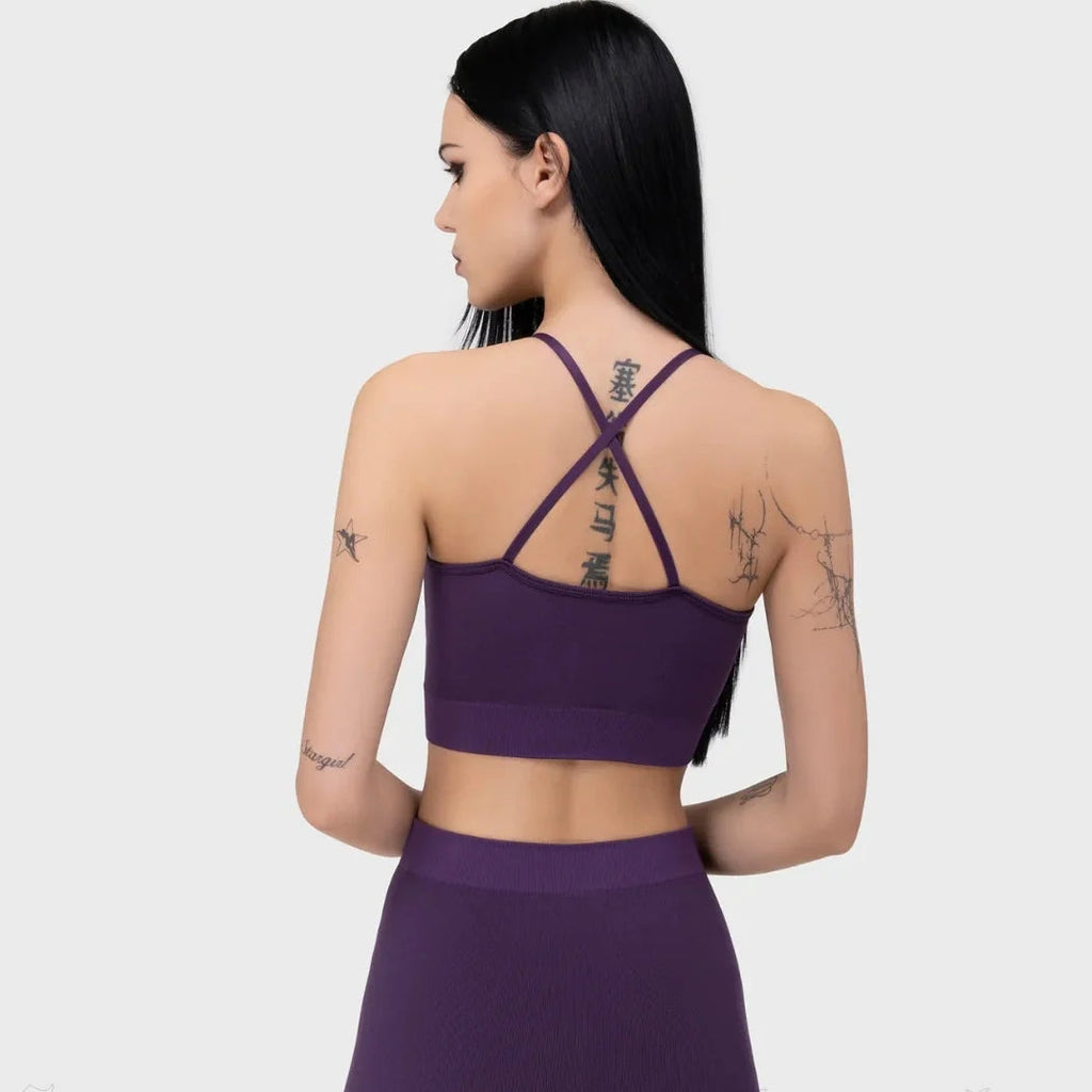 Person wearing a purple sports bra and shorts set on a white background